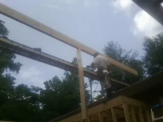 Carpenter setting a ridge beam over a new addition frame — Ice Dam Removal by Roofing Brothers in Sabin