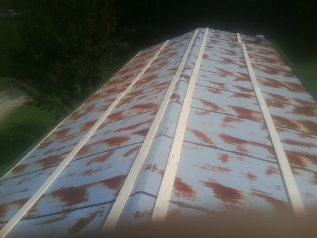 Rusted metal roof panels with new wood purlins before replacement — Storm Damage Roof Repair in Sabin by Roofing Brothers
