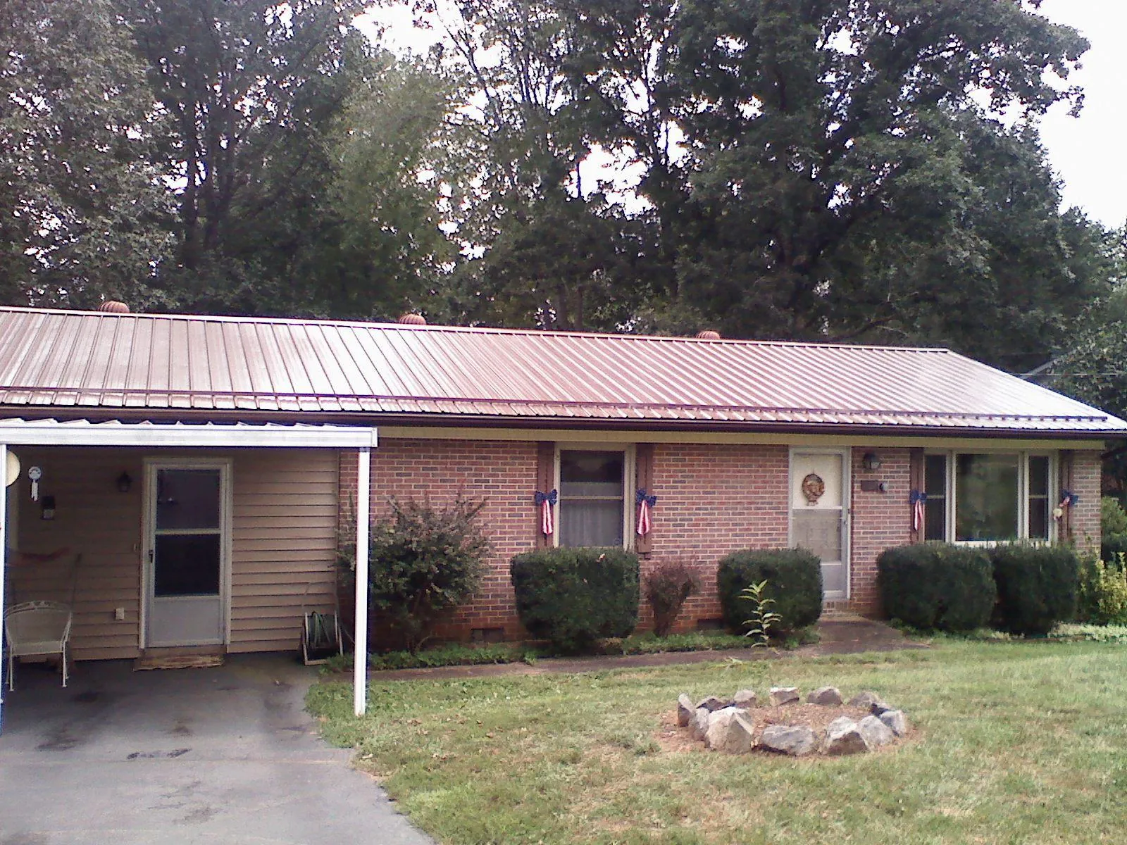 Bronze metal roof and carport on a brick ranch home — Roof Repair work by our crew in Sabin